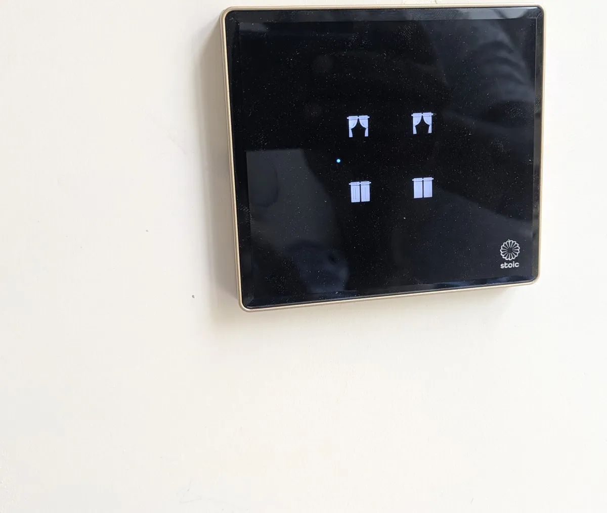 Stoic motorised curtain controller — gold-trim glass panel with four zone controls