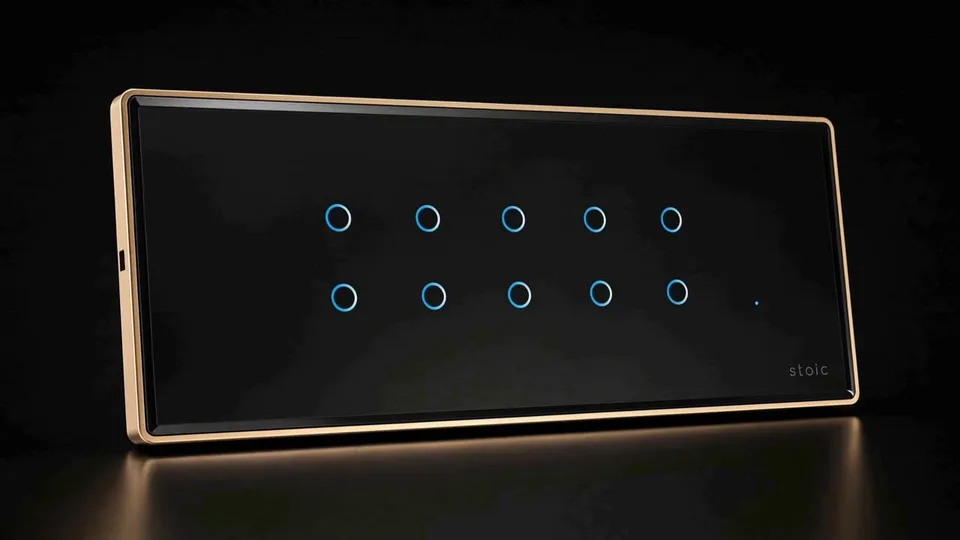 Illustrative render of a Stoic ZXD Zigbee Edge touch panel in black glass with blue ring indicators and a gold frame